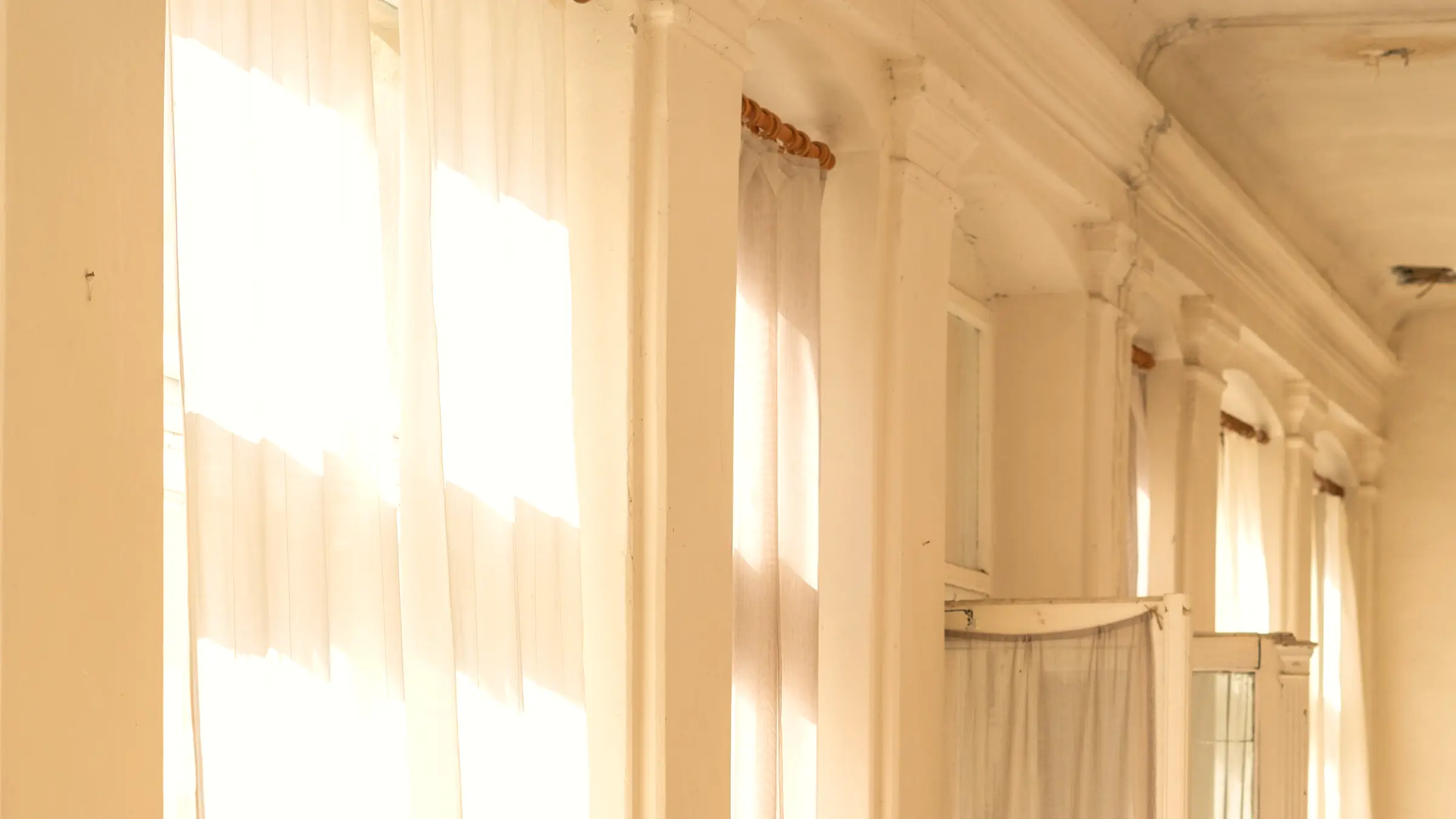 La lumière traversante d’un couloir, voilages et arches